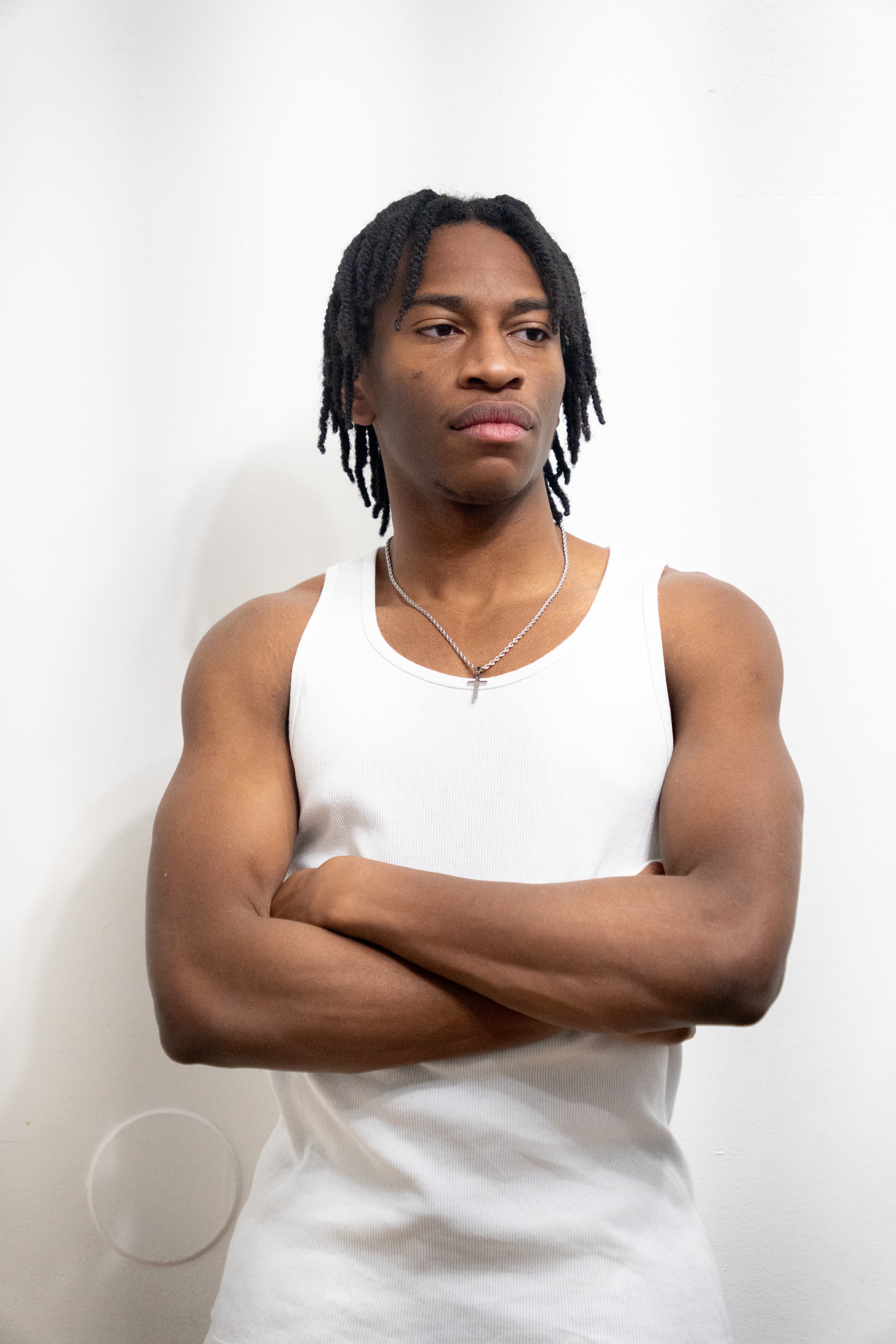 Studio portrait — white tank, arms crossed