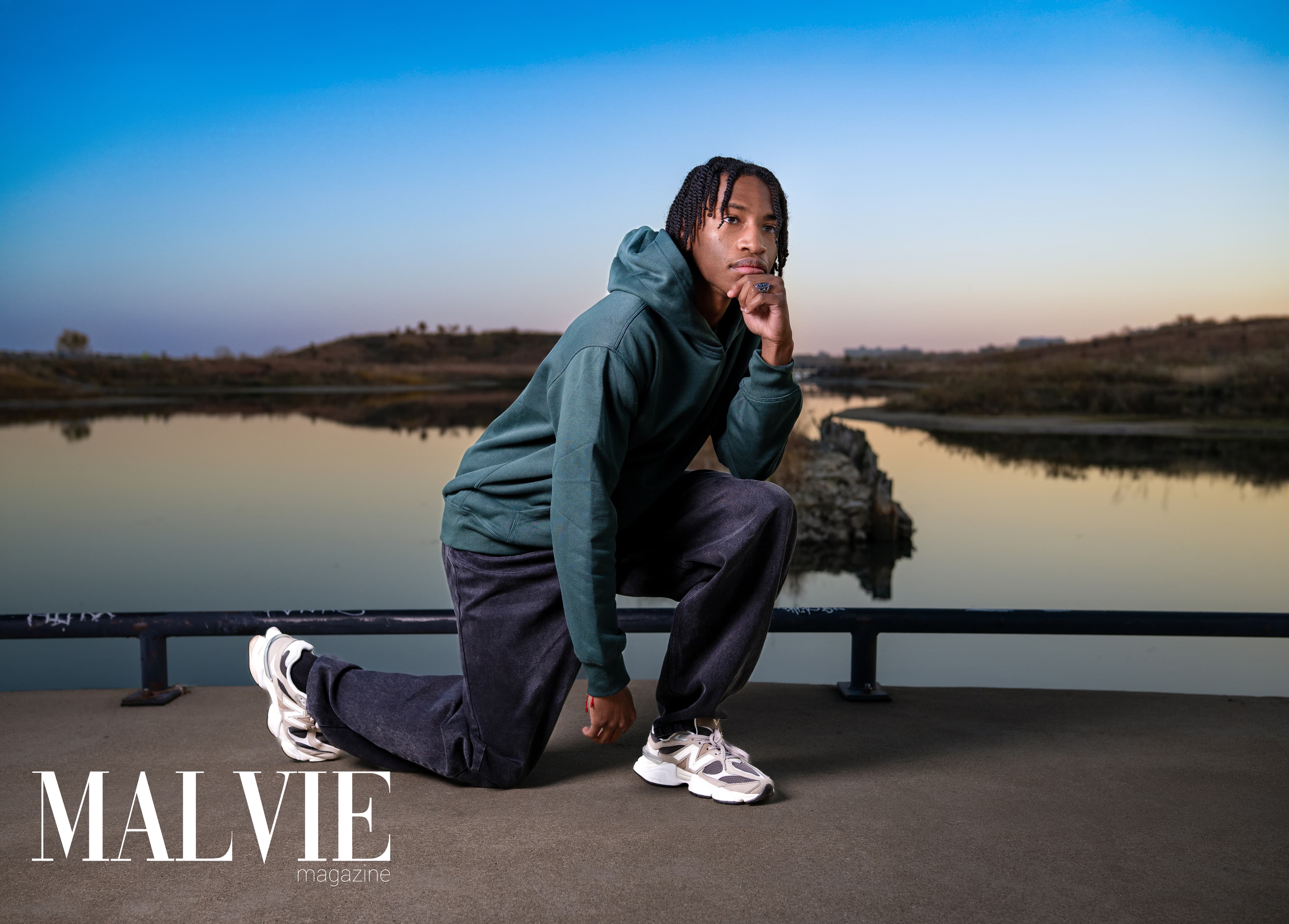 MALVIE Magazine — kneeling by water at sunset